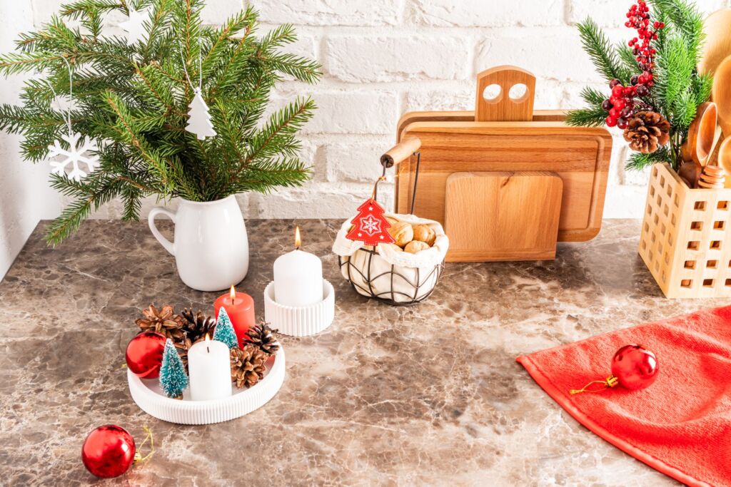 Part Of A Marble Countertop In The Kitchen With A Bouquet Of Spruce Branches, A Tray With Burning Candles, Decorations For The New Year And Christmas